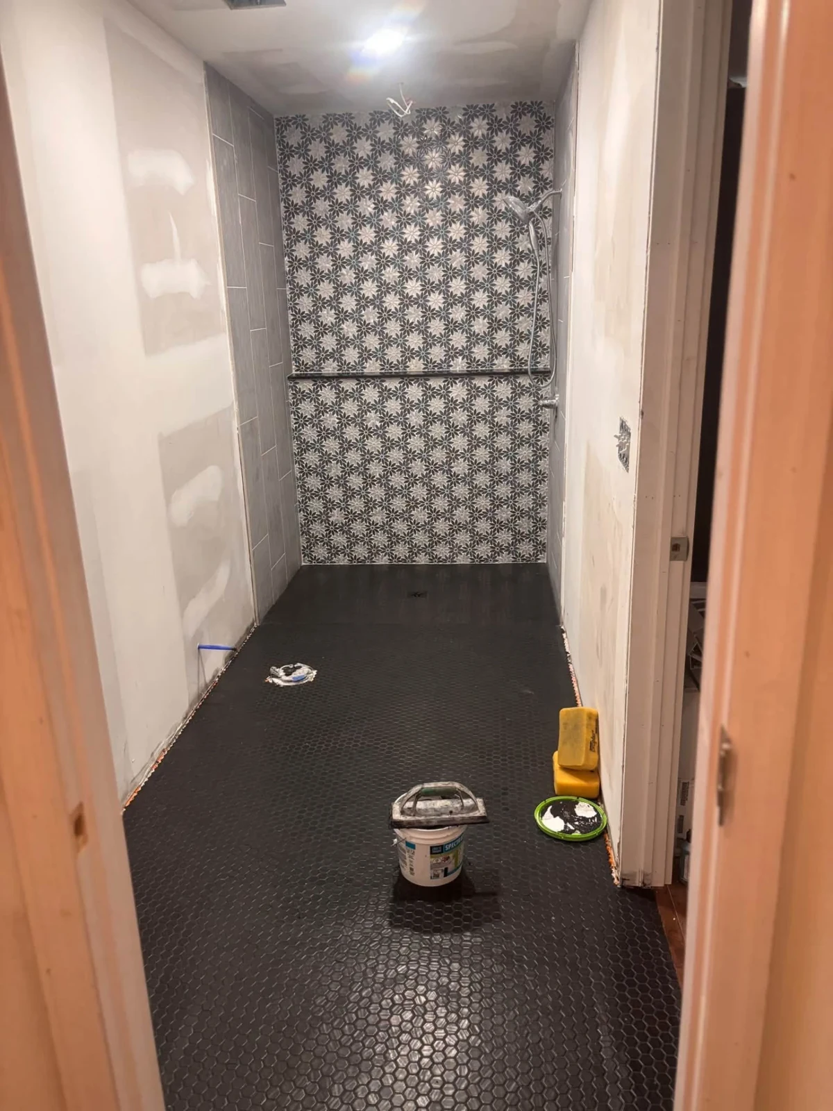 A patterned feature wall and dark mosaic floor. Work in progress.